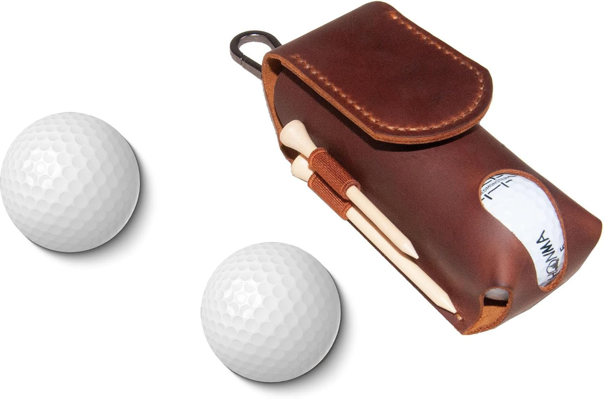 Two white golf balls and a brown leather pouch with tees and a divot tool.